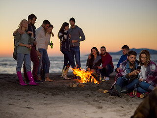 Image showing Couple enjoying bonfire with friends on beach