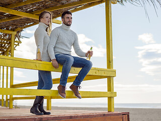 Image showing young couple drinking beer together at the beach