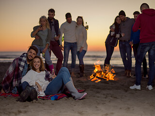 Image showing Couple enjoying with friends at sunset on the beach