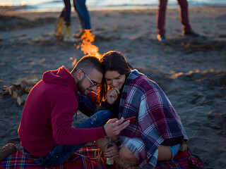 Image showing Couple enjoying bonfire with friends on beach