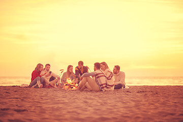 Image showing Group Of Young Friends Sitting By The Fire at beach