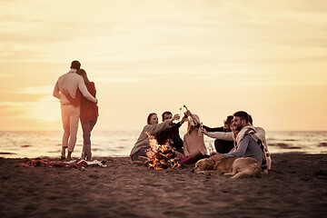 Image showing Couple enjoying with friends at sunset on the beach