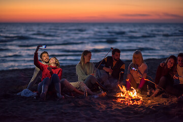 Image showing a group of friends enjoying bonfire on beach