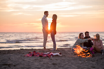 Image showing Couple enjoying with friends at sunset on the beach