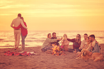 Image showing Couple enjoying with friends at sunset on the beach