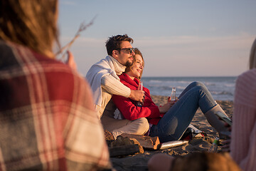 Image showing Couple enjoying with friends at sunset on the beach