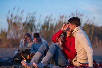 Image showing Couple enjoying with friends at sunset on the beach