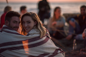 Image showing Couple enjoying with friends at sunset on the beach