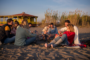 Image showing Couple enjoying with friends at sunset on the beach