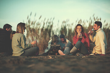 Image showing Couple enjoying with friends at sunset on the beach