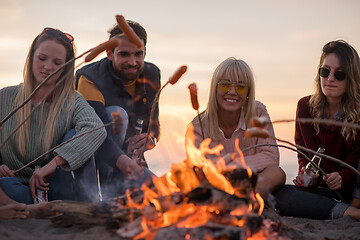 Image showing Group Of Young Friends Sitting By The Fire at beach