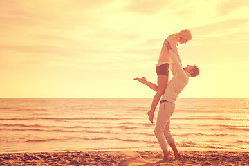 Image showing Loving young couple on a beach at autumn sunny day