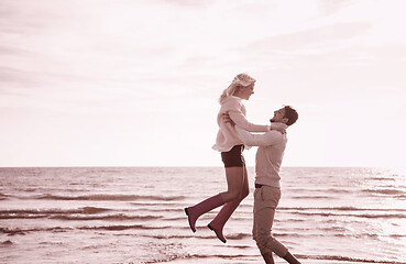 Image showing Loving young couple on a beach at autumn sunny day