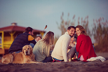 Image showing Couple enjoying with friends at sunset on the beach