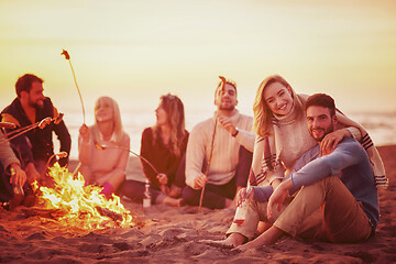 Image showing Group Of Young Friends Sitting By The Fire at beach