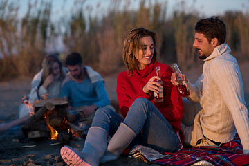 Image showing Couple enjoying with friends at sunset on the beach