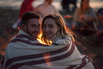 Image showing Couple enjoying with friends at sunset on the beach