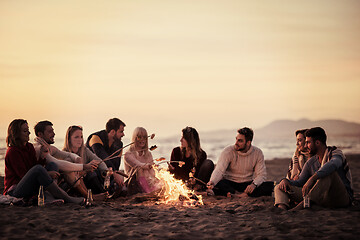 Image showing Group Of Young Friends Sitting By The Fire at beach