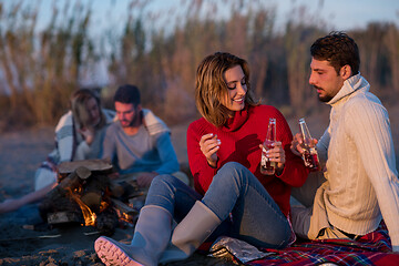 Image showing Couple enjoying with friends at sunset on the beach