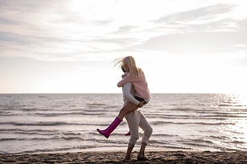 Image showing Loving young couple on a beach at autumn sunny day