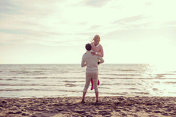 Image showing Loving young couple on a beach at autumn sunny day