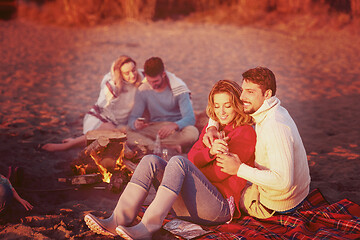 Image showing Couple enjoying with friends at sunset on the beach