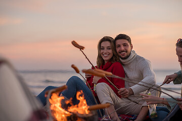 Image showing Group Of Young Friends Sitting By The Fire at beach