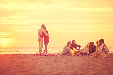 Image showing Couple enjoying with friends at sunset on the beach