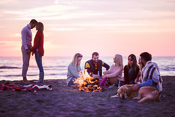 Image showing Couple enjoying with friends at sunset on the beach