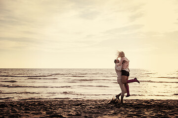 Image showing Loving young couple on a beach at autumn sunny day