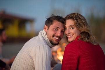 Image showing Couple enjoying with friends at sunset on the beach