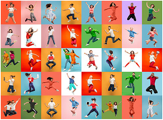 Image showing Freedom in moving. Pretty young women and men jumping against colorful background