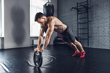 Image showing The athlete trains hard in the gym. Fitness and healthy life concept.
