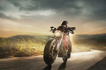 Image showing Motorcyclist in black helmet driving motorbike