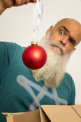 Image showing bearded man looking at red christmas ball