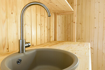 Image showing Sink with a mixer close-up in a kitchen set made of natural wood