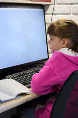 Image showing A girl studies at a computer with a large monitor, view from the