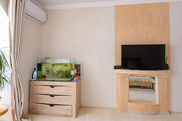 Image showing A corner in the room, there is an aquarium, an air conditioner hangs and a stylized place for a TV