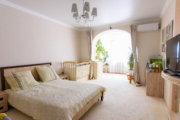 Image showing Nice interior of a bedroom combined with a balcony and a crib for a newborn baby