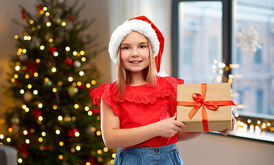 Image showing girl in santa hat with christmas gift at home