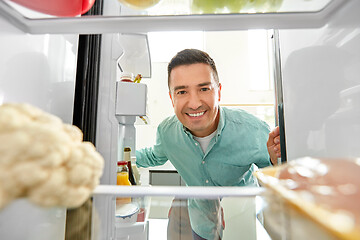 Image showing man looking for food in fridge at kitchen