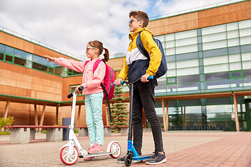 Image showing happy school children with backpacks and scooters