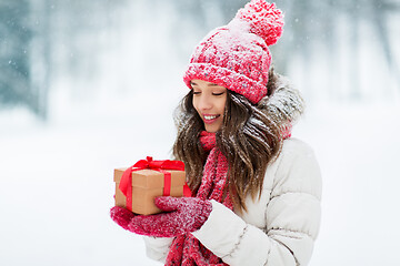 Image showing happy young woman with christmas gift in winter