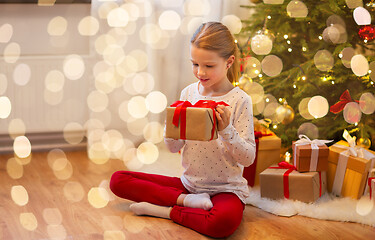 Image showing smiling girl with christmas gift at home