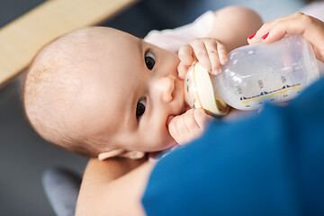 Image showing close up of mother feeding baby with milk formula