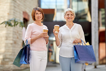 Image showing senior women with shopping bags and coffee in city