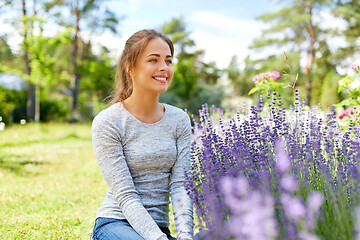 Image showing young woman and lavender flowers at summer garden