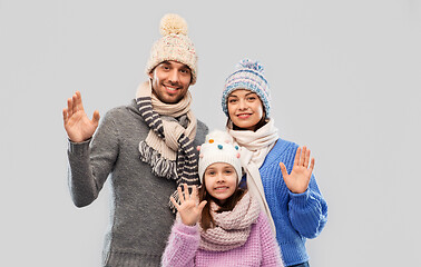 Image showing happy family in winter clothes waving hands