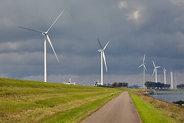 Image showing Wind tubines along the waterside