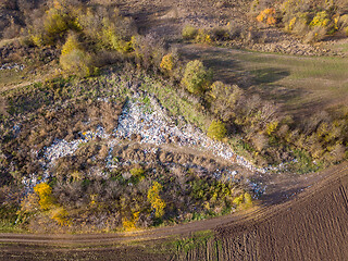 Image showing Aerial view from drone above dumpsite surrounded by trees.